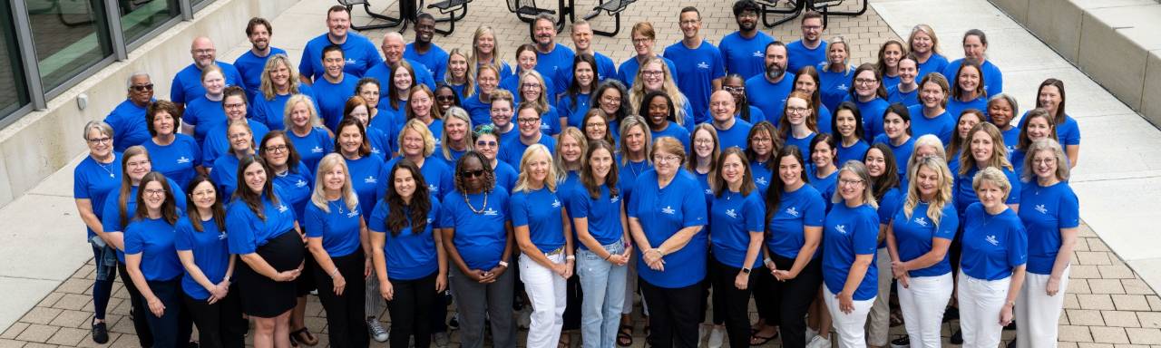 Group of people wearing blue polo shirts holding a laker nurse sign